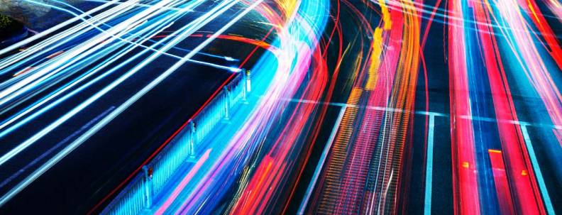 Streaks of light show the movement of traffic in the dark at a busy road junction