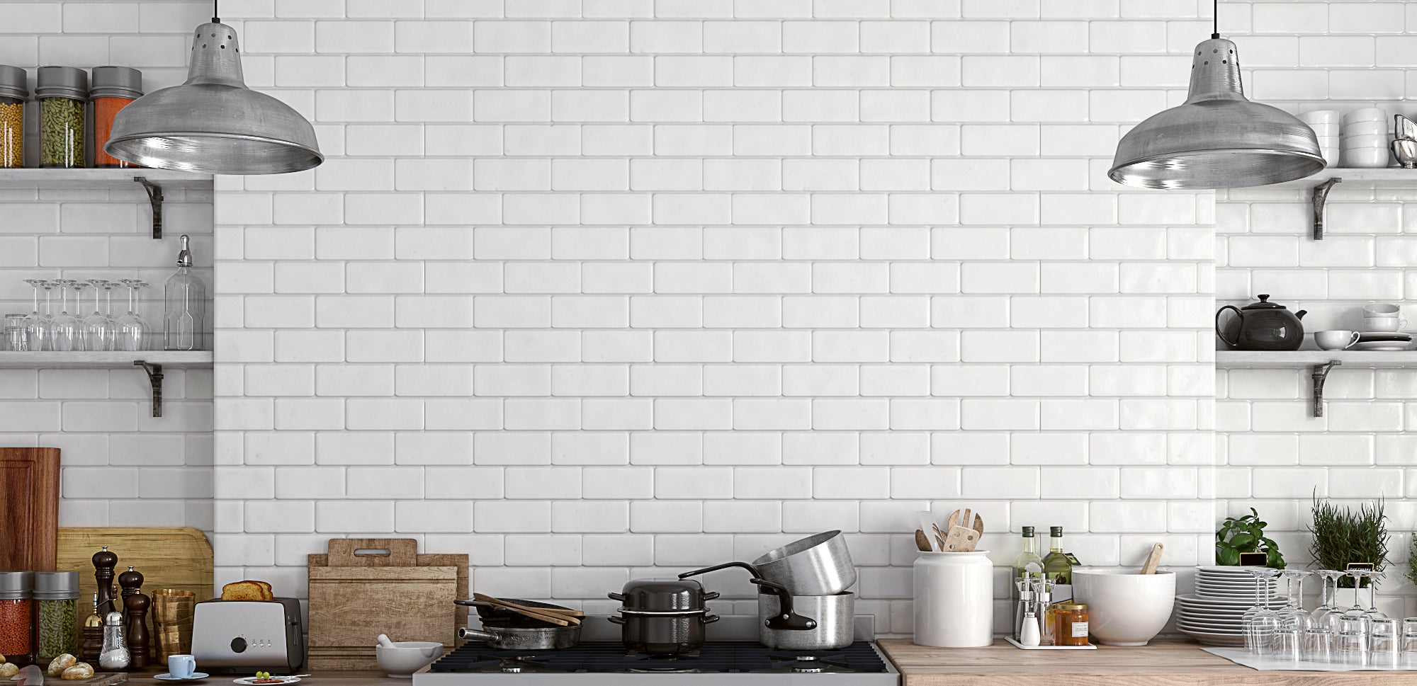 A brick kitchen wall, painted white, with cooking utensils lined up in front of it.